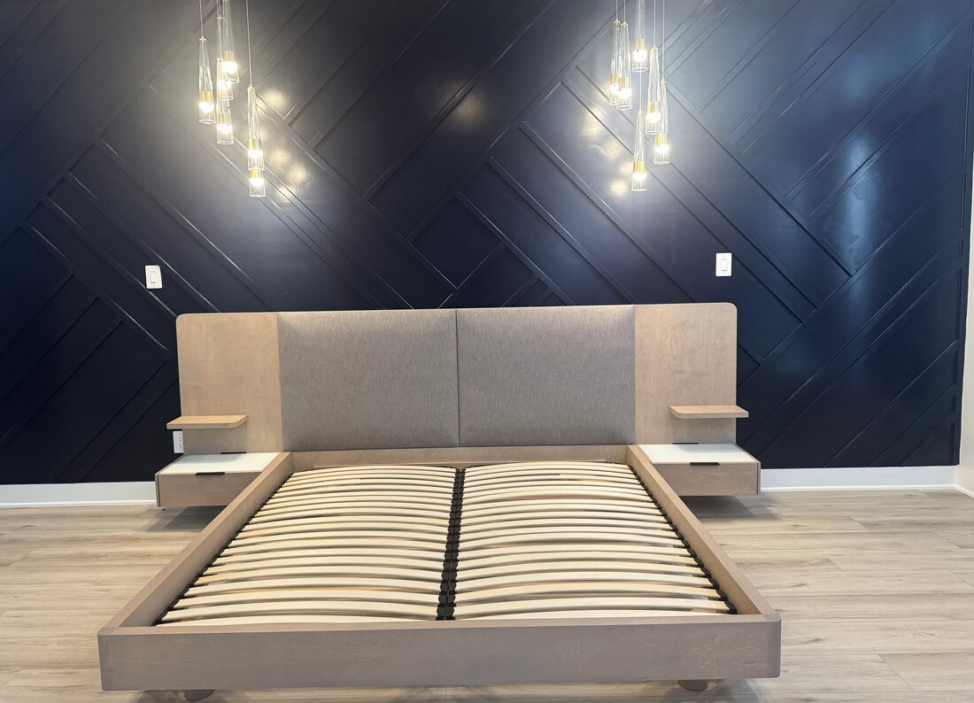 Designer platform bed and nightstands delivered and assembled against a navy accent wall by J&J Vanlines